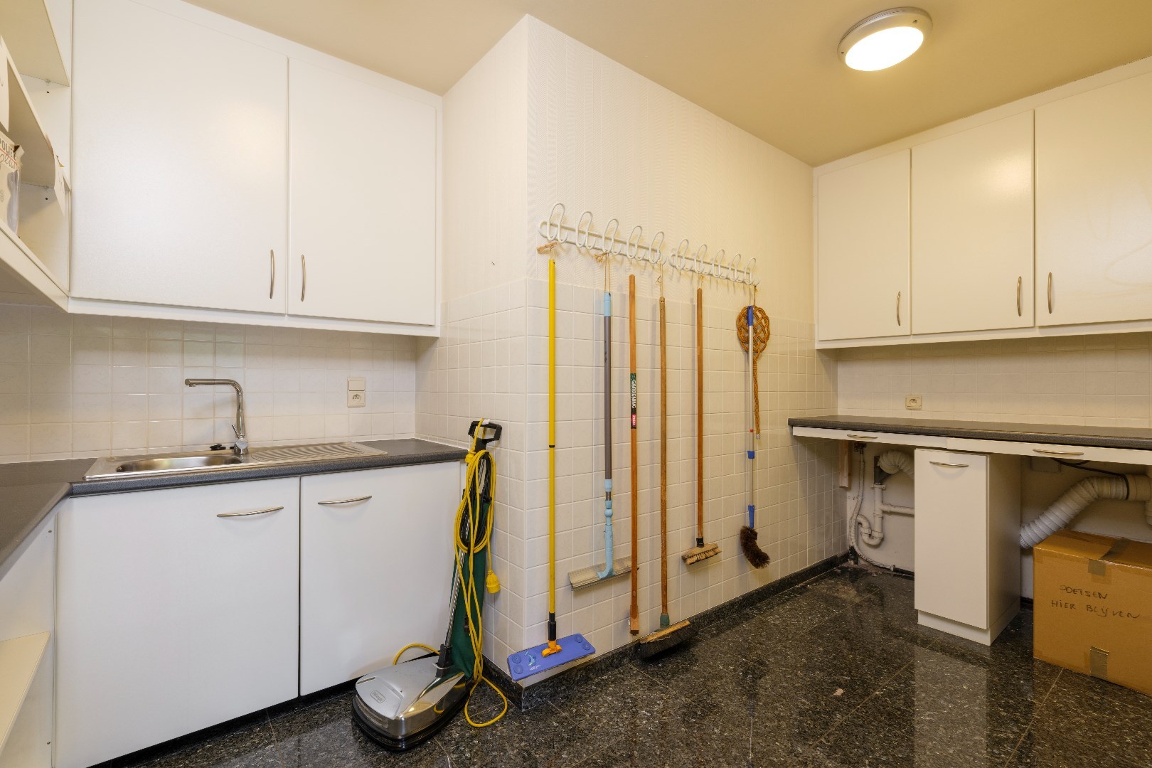 Aparte berging/wasplaats met aansluiting voor wasmachine en droogkast, ook voorzien van voldoende kastruimte en wasbak 