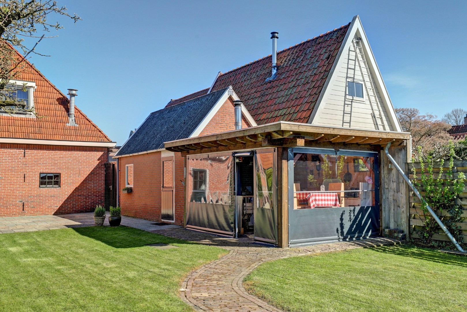 Vrijstaande woning met diepe zonnige tuin, overkapping en royale bijgebouwen 