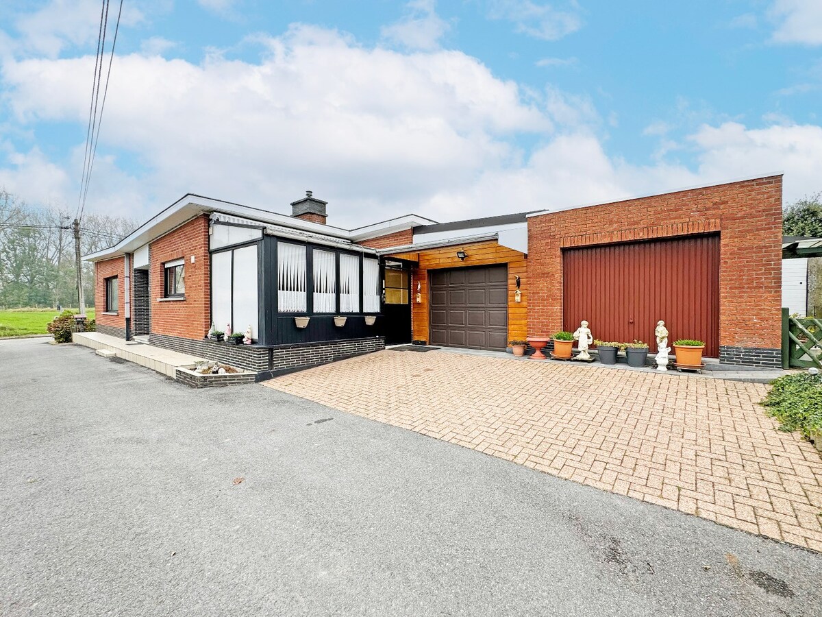 Seventies laagbouw met 2 garages en tuin te Erwetegem 