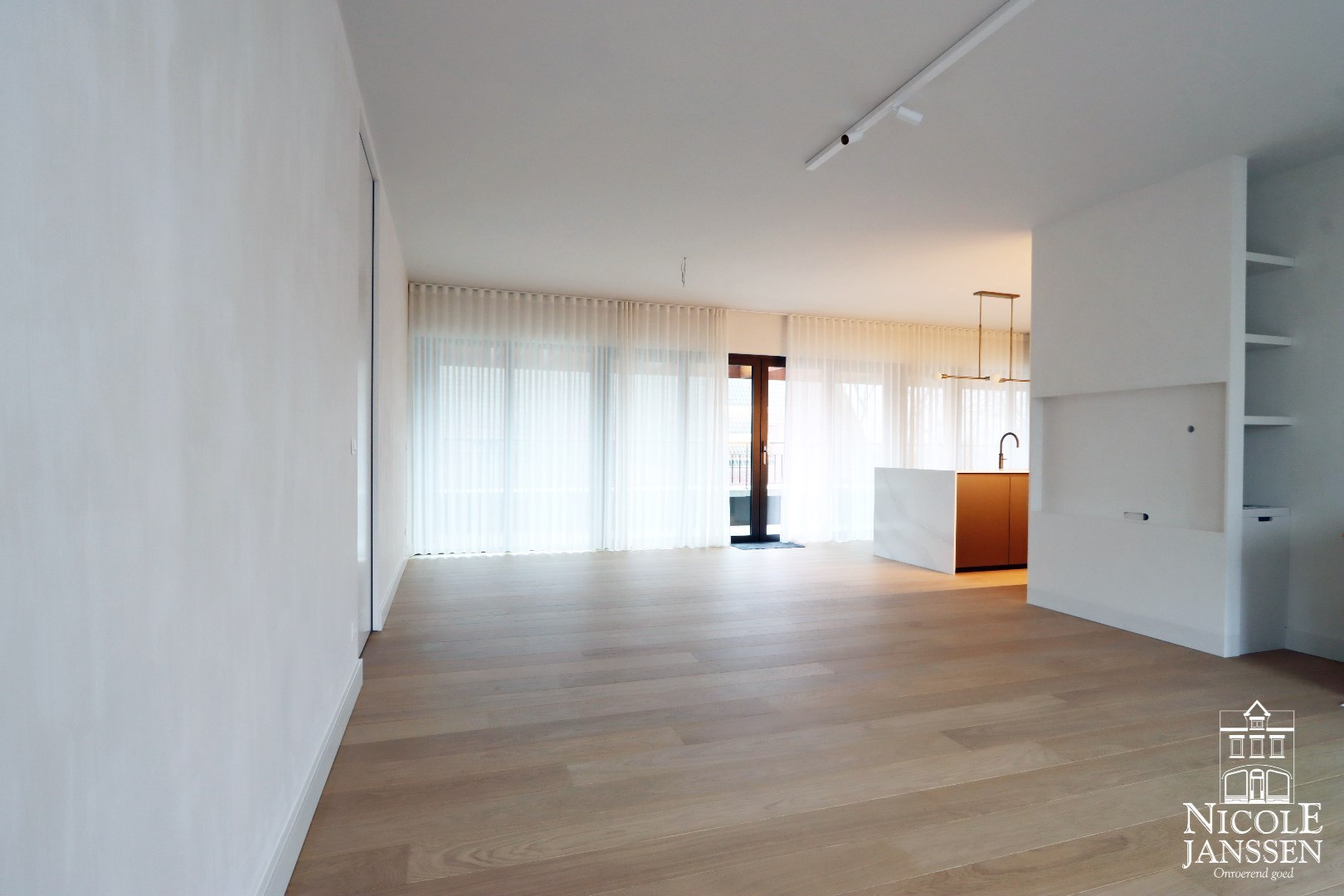 Ruime woonkamer met open keuken en toegang tot terras