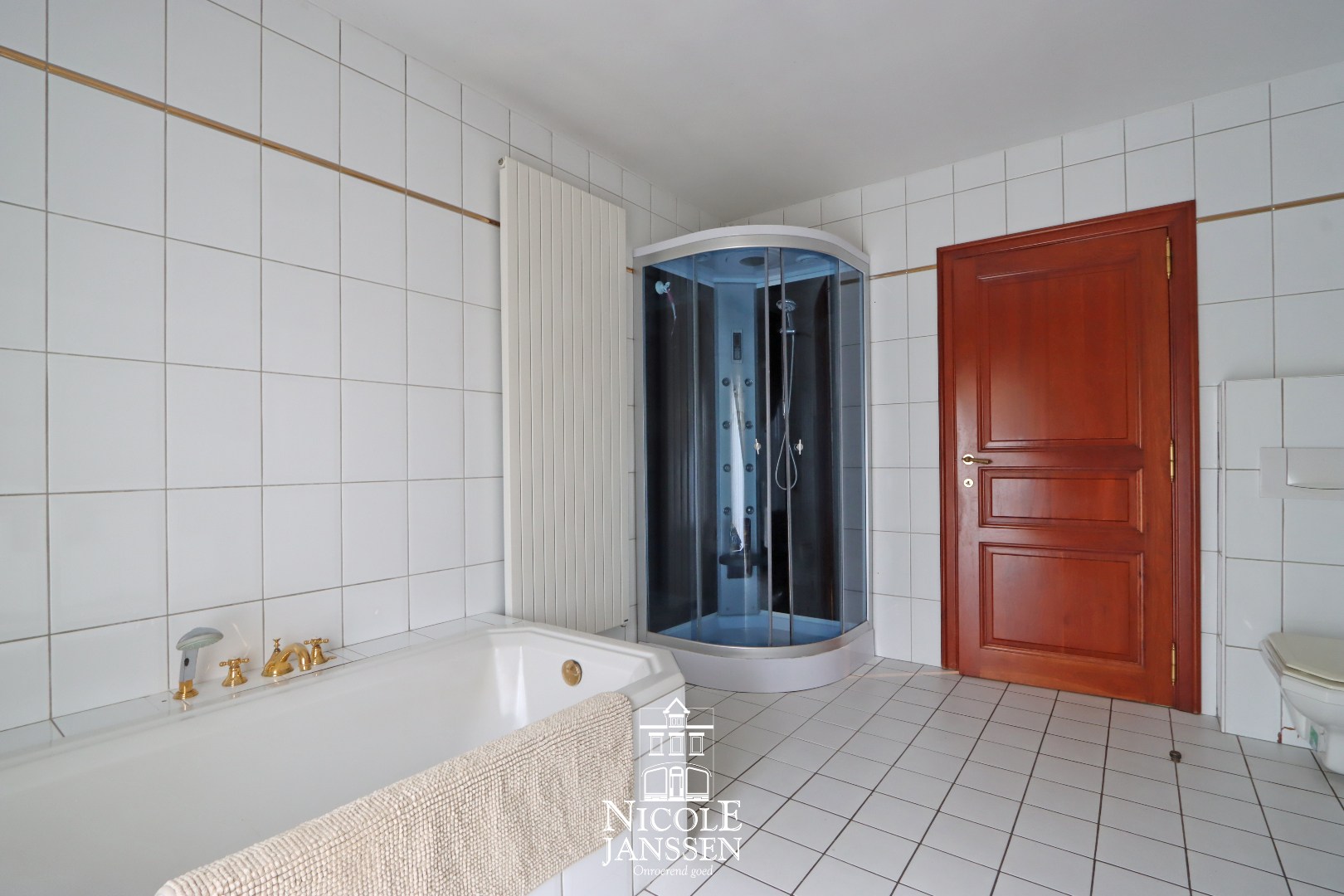 Badkamer met ligbad, douche, dubbele lavabo en toilet