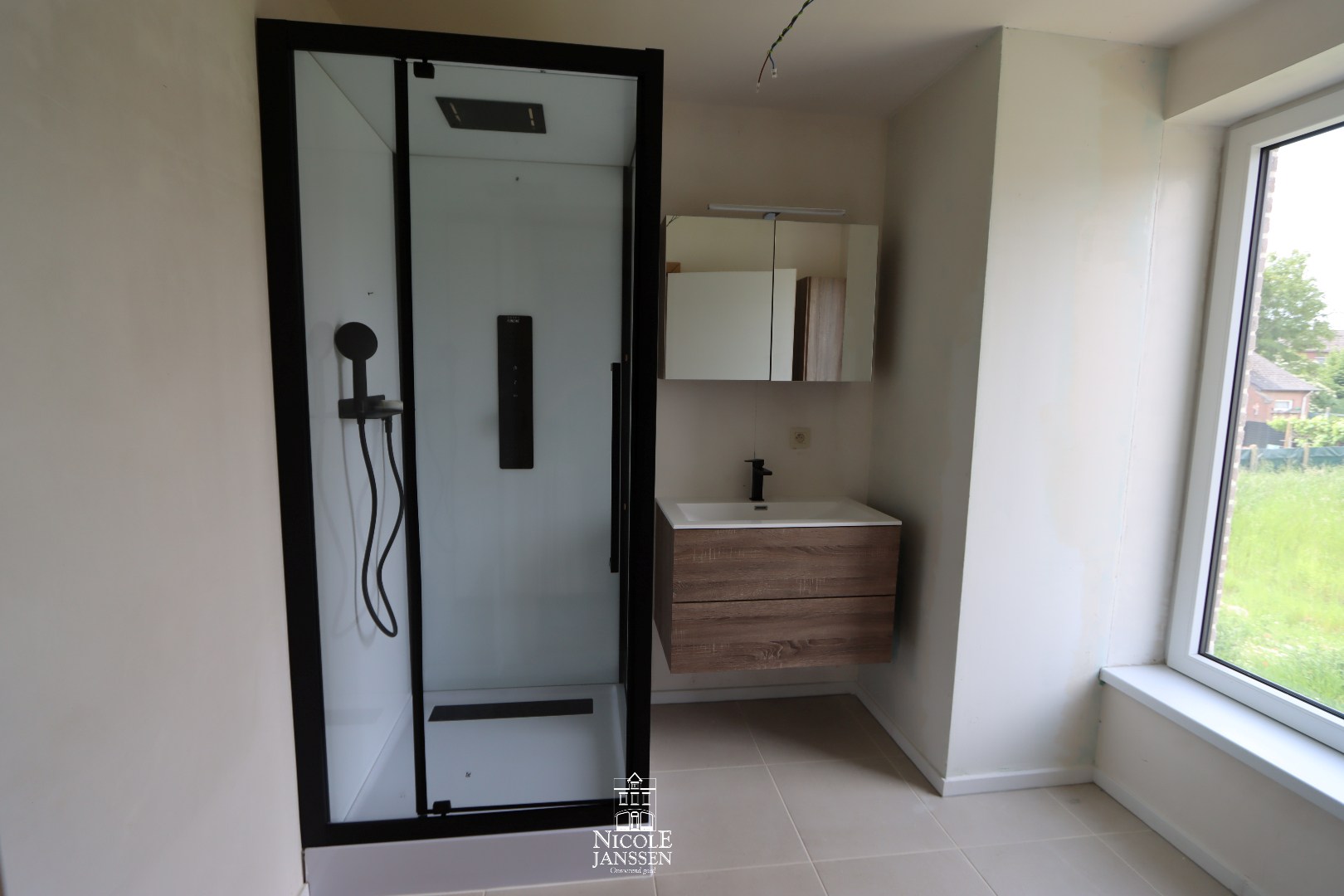 Badkamer met douche en enkele wastafel in badkamermeubel