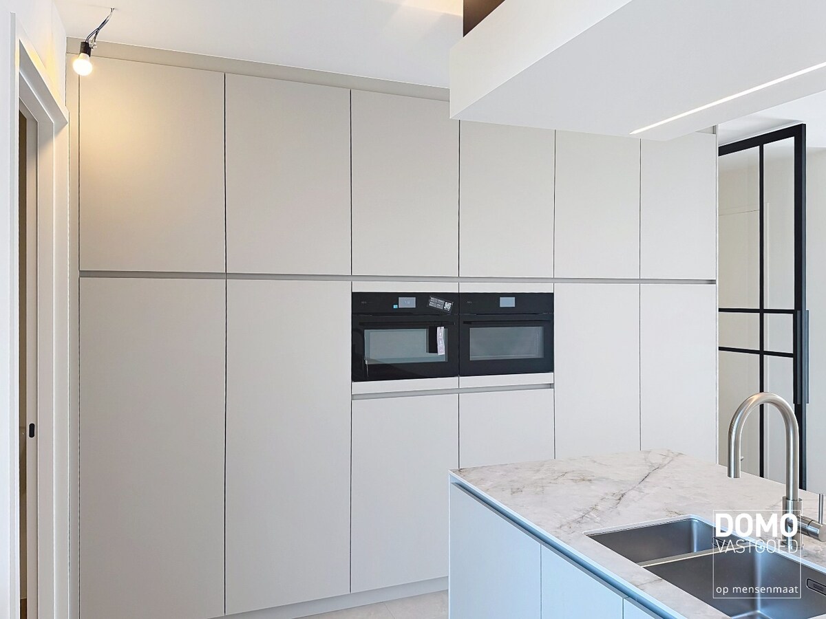 HOOGWAARDIG AFGEWERKT APPARTEMENT VAN 122,50 M² MET 2 SLAAPKAMERS, RUIM TERRAS EN PARKEERPLAATS TE CENTRUM TUILT 