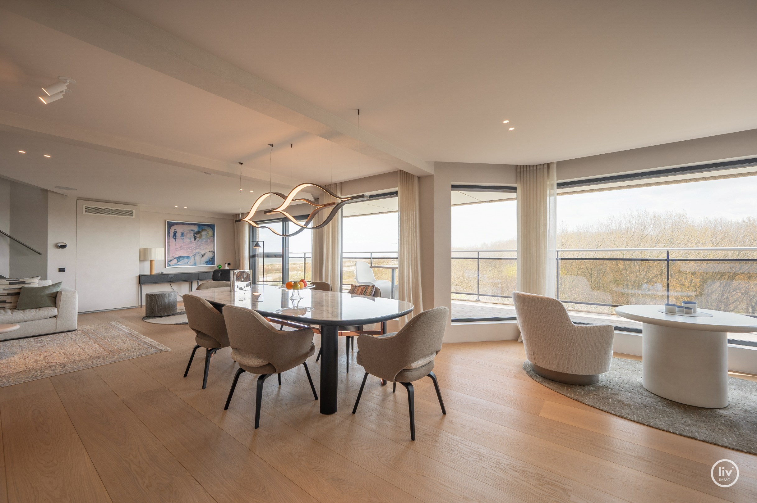 Dit magnifieke duplexappartement combineert uitzonderlijke volumes met adembenemende zichten over zowel de omliggende bossen als de zee. 