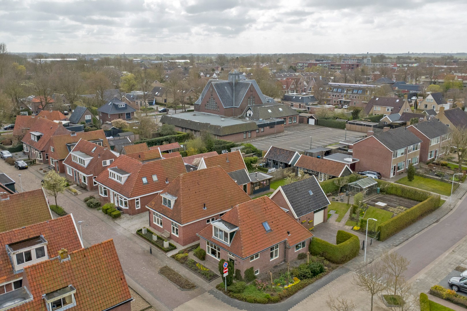 Vrijstaande woning met diepe zonnige tuin, overkapping en royale bijgebouwen 