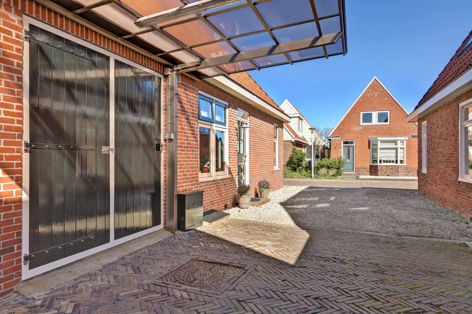 Vrijstaande woning met diepe zonnige tuin, overkapping en royale bijgebouwen 