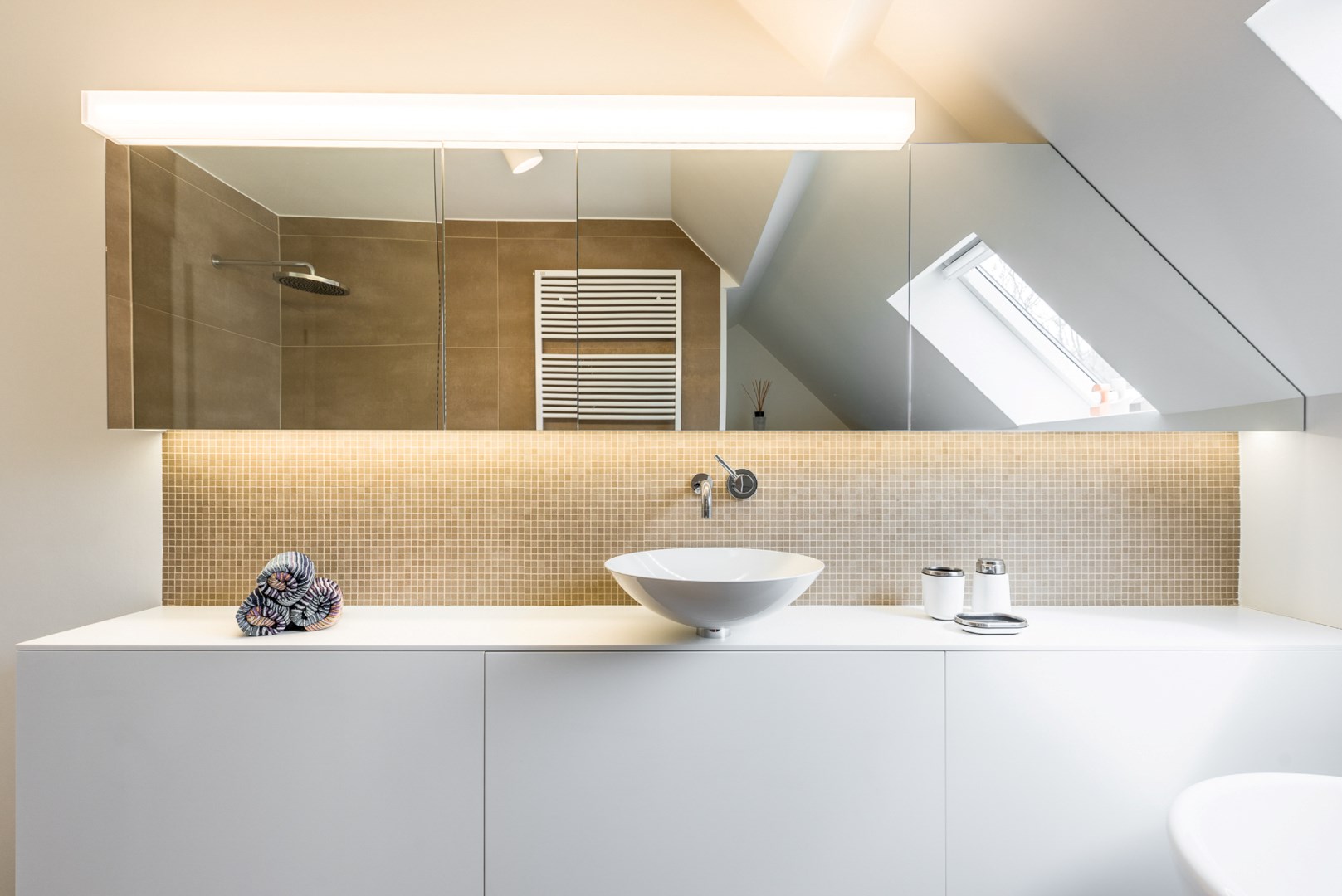 Luxueus ingerichte badkamer met inloopdouche, vrijstaand bad en enkele lavabo op fraai badkamermeubel 