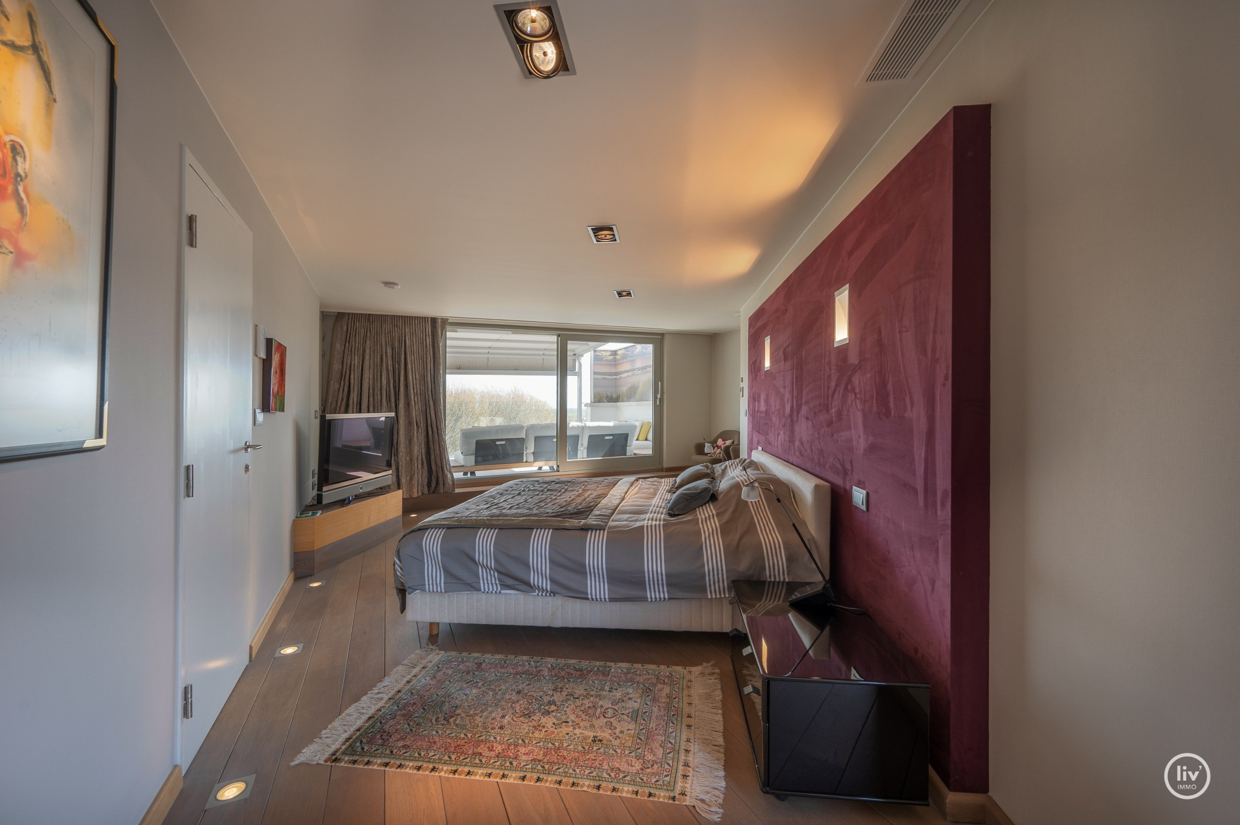 Dit magnifieke duplexappartement combineert uitzonderlijke volumes met adembenemende zichten over zowel de omliggende bossen als de zee. 