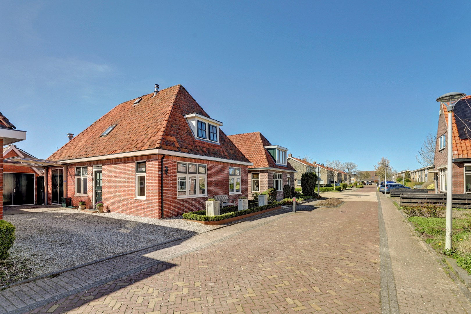 Vrijstaande woning met diepe zonnige tuin, overkapping en royale bijgebouwen 