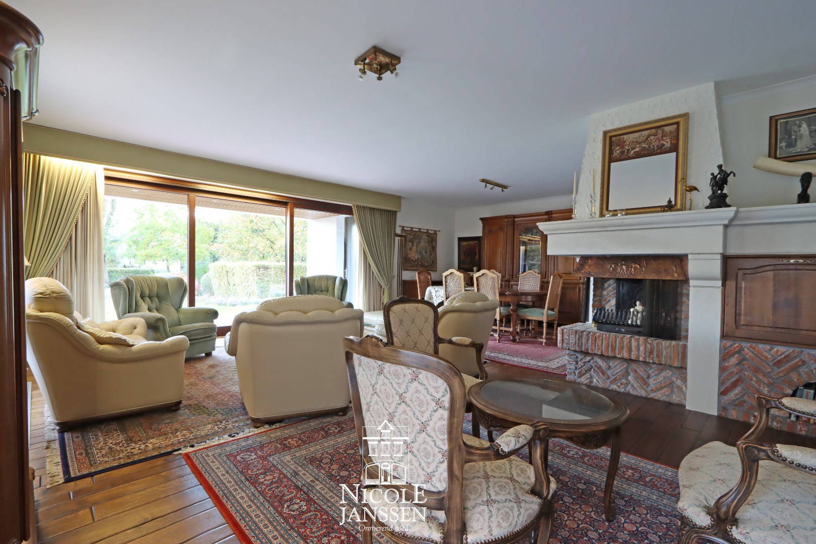 L-vormige woonkamer met parketvloer en gashaard 