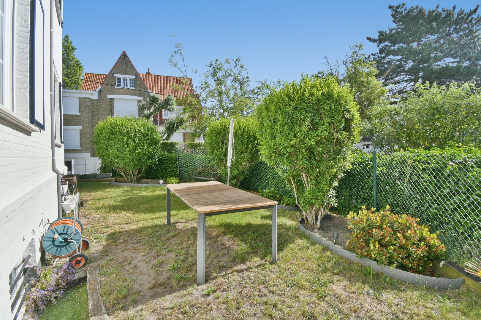 Instapklaar gelijkvloers appartement met privatieve toegang, garage, zonnige tuin en terras nabij zee 