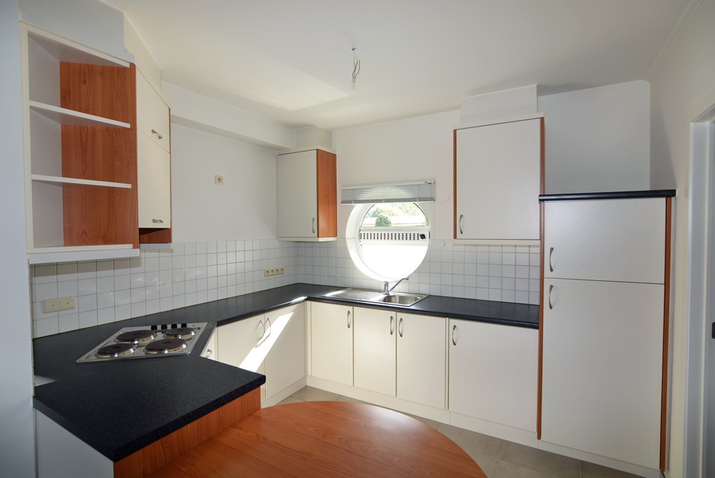 Gelijkvloers appartement (121 m²) met 2 slpks, overdekt terras, garage en kelderberging. 