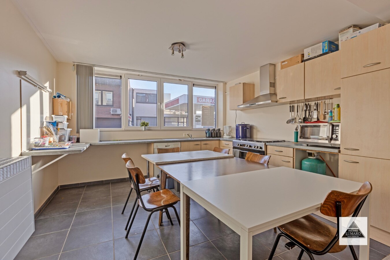 Handelsgelijkvloers en 2 appartementen en parking. Perceel van 15a 49ca. 