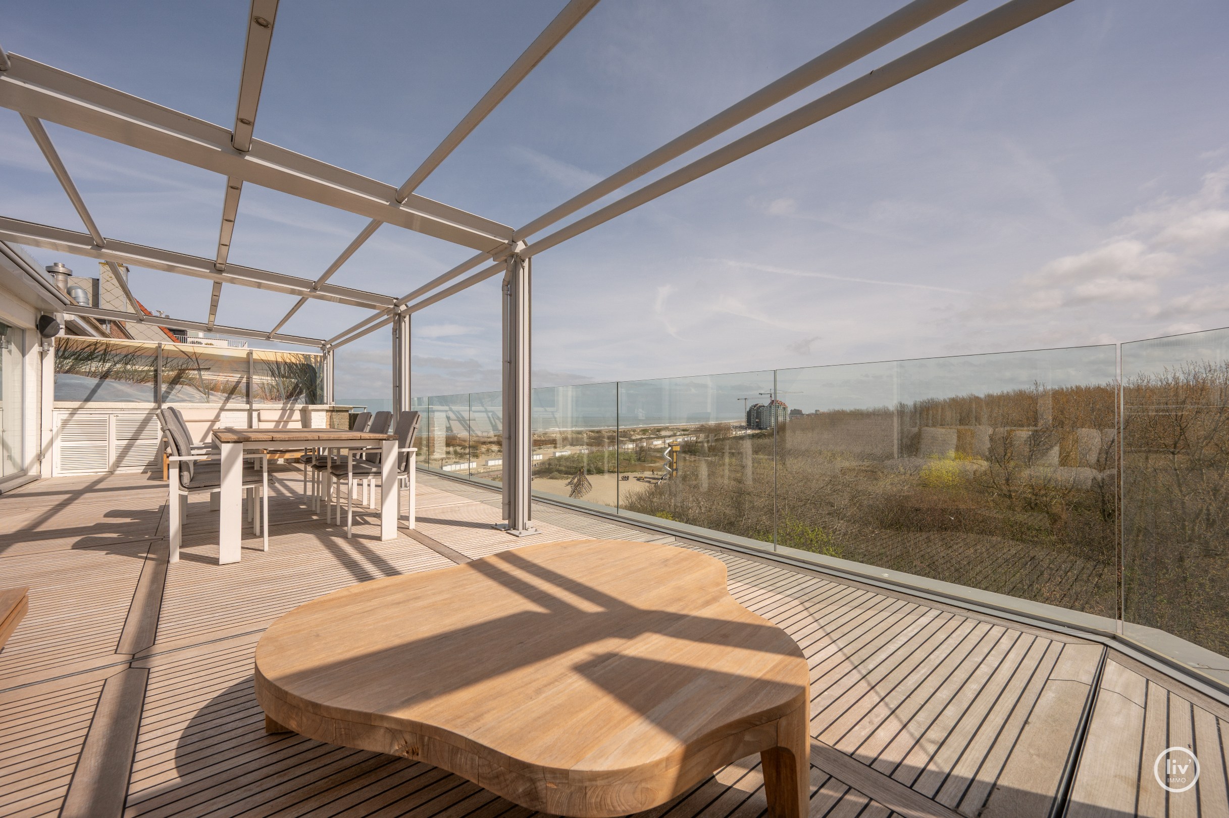 Dit magnifieke duplexappartement combineert uitzonderlijke volumes met adembenemende zichten over zowel de omliggende bossen als de zee. 