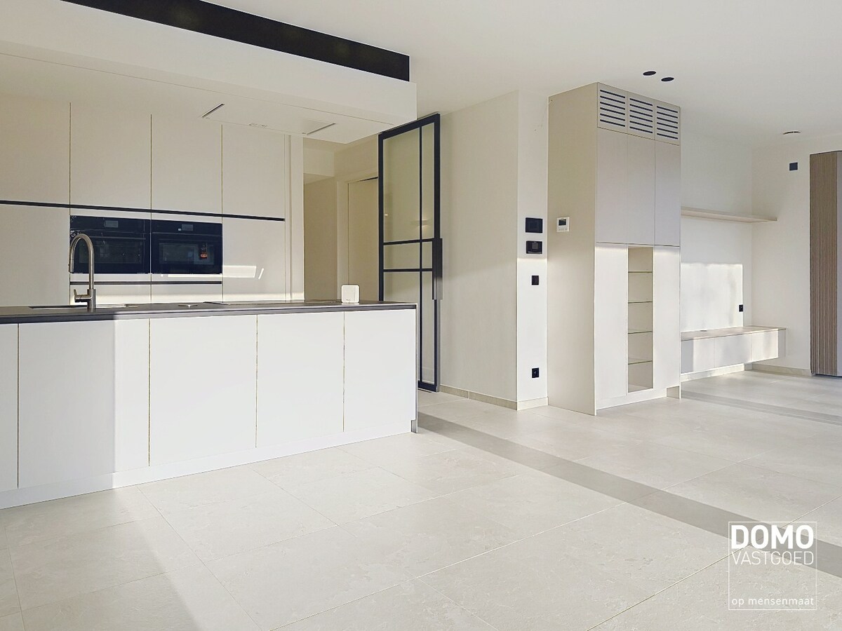 HOOGWAARDIG AFGEWERKT APPARTEMENT VAN 122,50 M² MET 2 SLAAPKAMERS, RUIM TERRAS EN PARKEERPLAATS TE CENTRUM TUILT 