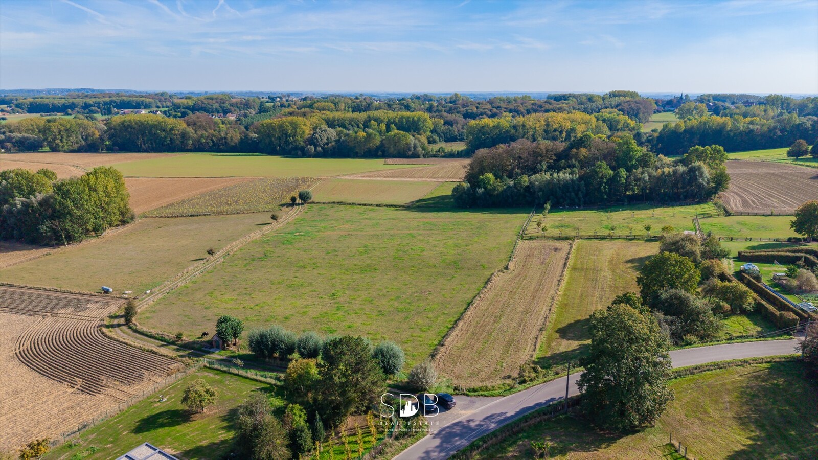 Landelijke hoeve met bijgebouwen en aanpalende graslanden op 14.677m² 