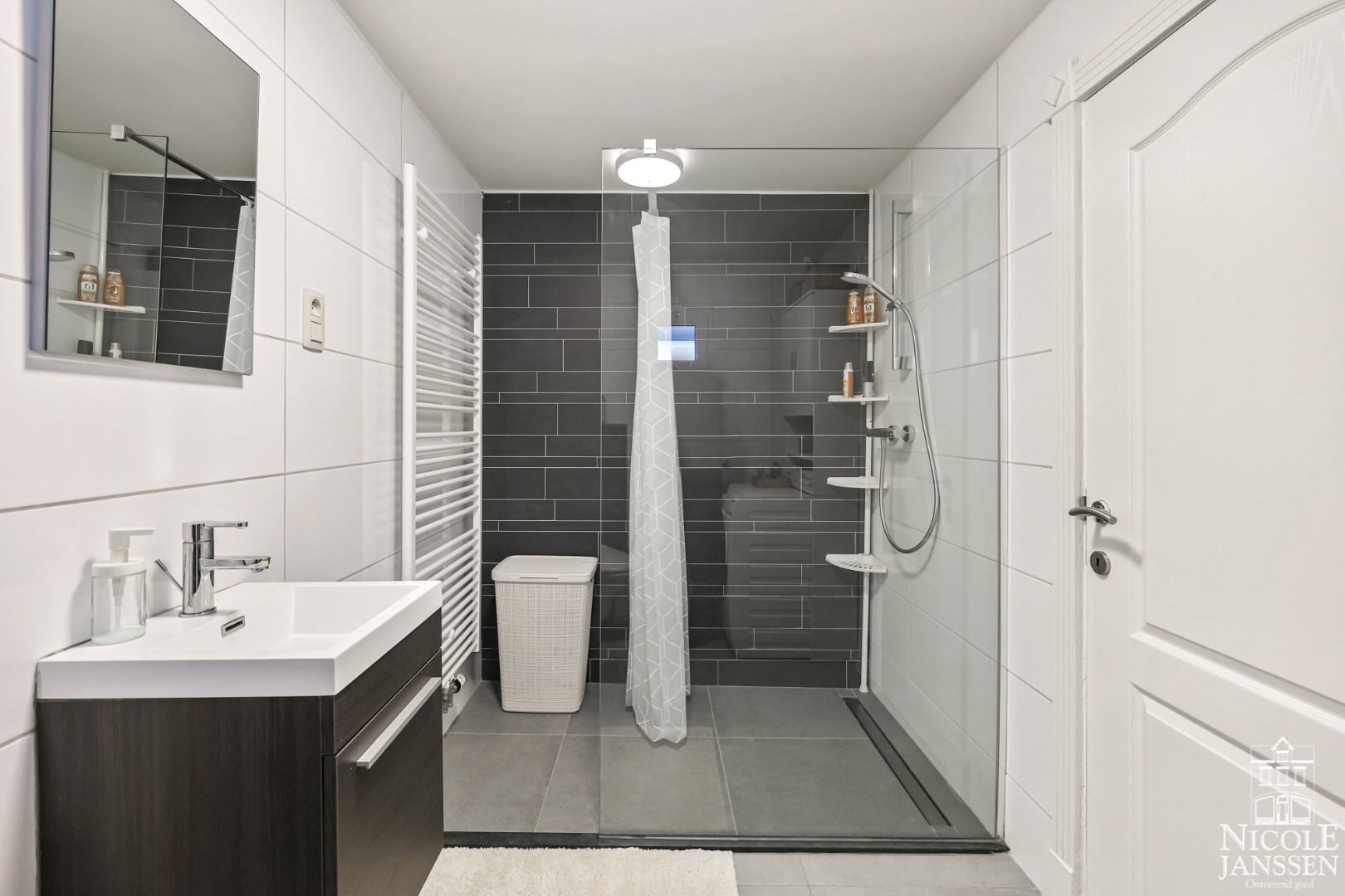 Volledig betegelde badkamer met inloopdouche, toilet en wastafel 