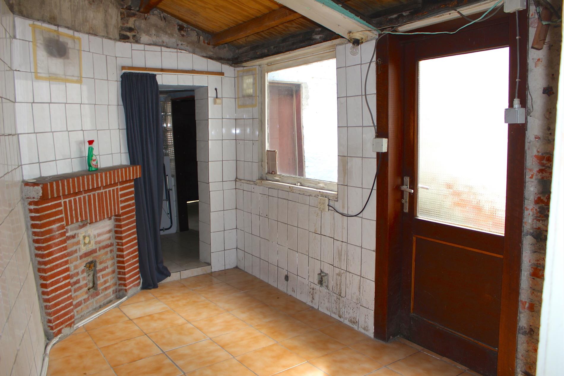 Te renoveren rijwoning met zonnige tuin 