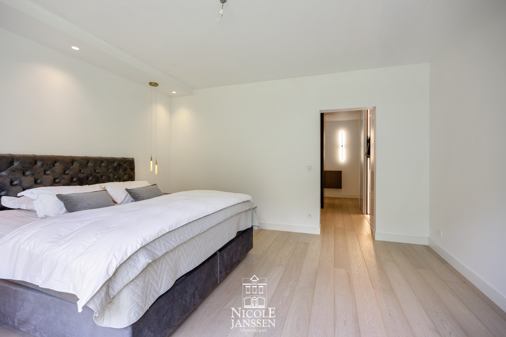 Ruime slaapkamer met schuiframen die directe toegang bieden tot de tuin 