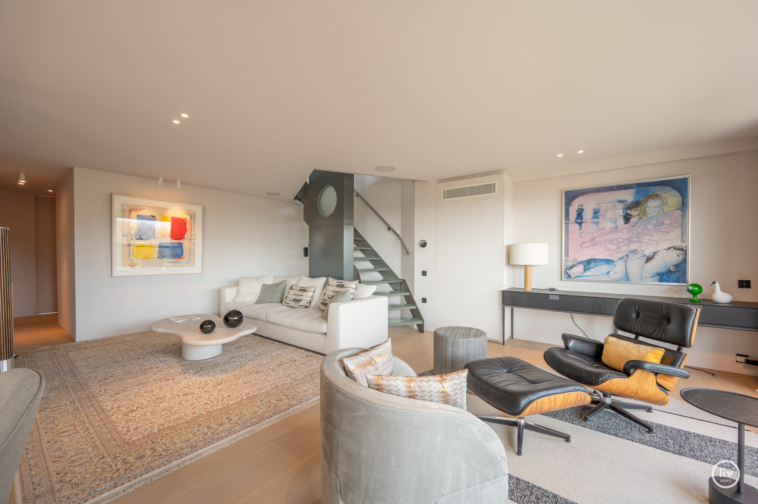 Dit magnifieke duplexappartement combineert uitzonderlijke volumes met adembenemende zichten over zowel de omliggende bossen als de zee. 