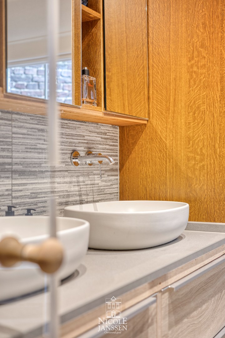 Badkamer voorzien van dubbele wastafel, inloopdouche en sauna